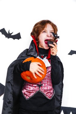 Balkabağına tutan bir vampir kostümü içinde mutlu çocuk