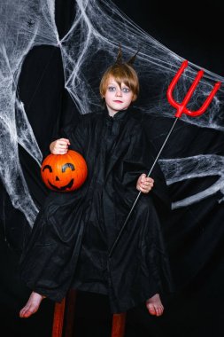 Kabak bir örümcek ağı ile siyah arka plan üzerine oturan sevimli küçük çocuk