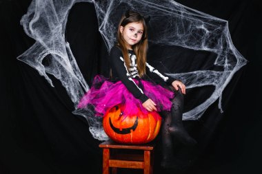 Kabak siyah arka plan üzerine oturan sevimli küçük kız