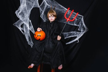 Kabak siyah arka plan üzerine oturan sevimli küçük çocuk