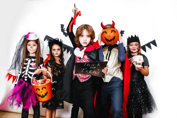 Halloween-feest. Grappige kinderen in carnaval kostuums op witte achtergrond — Stockfoto