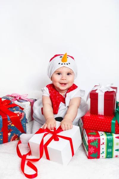 Bebé feliz en traje de muñeco de nieve con cajas de regalo de regalo de Navidad —  Fotos de Stock