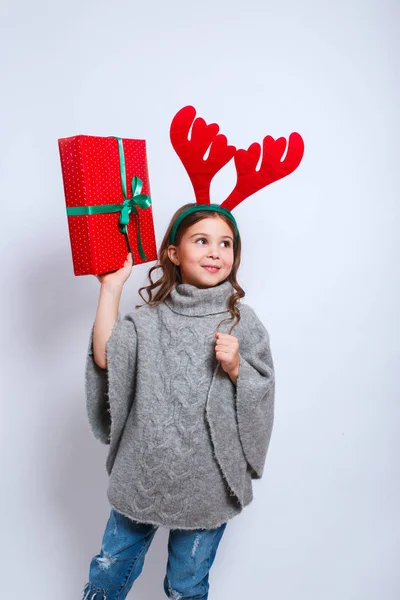 Feliz Navidad y feliz año nuevo .happy niña sonriente con cajas de regalo de Navidad.. Sonriente niño divertido en cuernos de ciervo —  Fotos de Stock