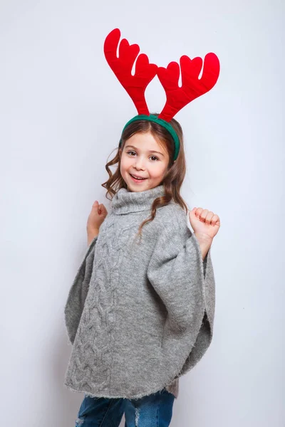 Feliz Navidad y feliz año nuevo. Sonriente niño divertido en cuernos de ciervo sobre fondo blanco —  Fotos de Stock