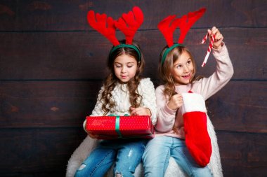 İki mutlu küçük gülümseyen kız Noel ile kutuları ahşap arka plan üzerinde hediye. Mutlu Noeller ve mutlu yeni yıl .