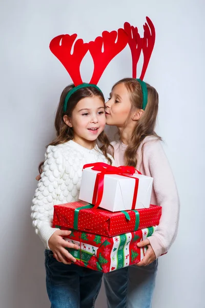 Две счастливые маленькие улыбающиеся девочки с рождественскими подарками. С Рождеством и Новым годом!  . — стоковое фото