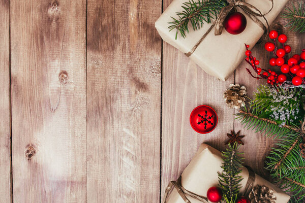 Рождественская подарочная коробка, декор и ветка елки на деревянном столе. Вид сверху с пространством для копирования