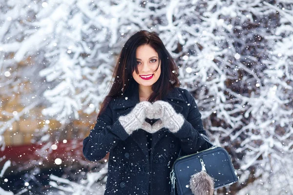 Primer plano retrato de chica feliz en guantes de lana mostrar el corazón y disfrutar de los momentos de invierno . —  Fotos de Stock