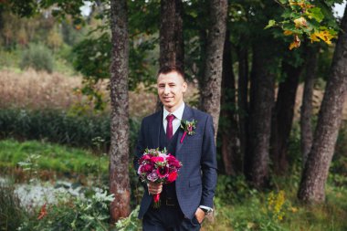 gülümseyen ve gelin için bekleyen düğün smokin, damat.