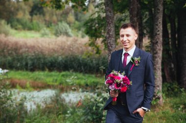 gülümseyen ve gelin için bekleyen düğün smokin, damat.