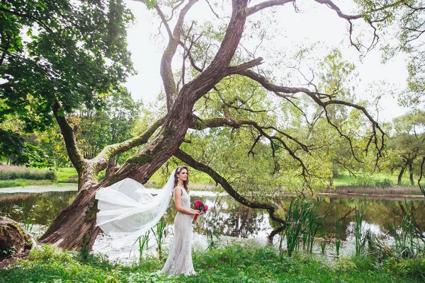 公園内の美しい花嫁。手に花のブーケを持った花嫁 — ストック写真