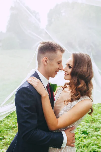 Close-up van romantische portret van mooie bruidspaar onder de sluier . — Stockfoto