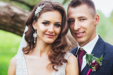 Güzel yeni evli gelin ve damat parkta sarılma.