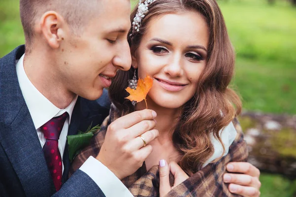 Sposo che abbraccia la sposa al parco. Matrimonio coppia — Foto Stock