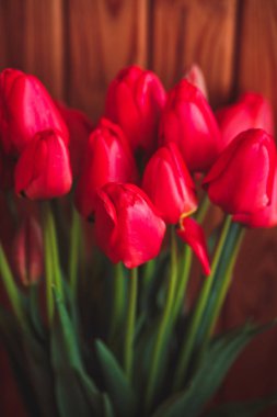ahşap masa üstünde kırmızı lale buketi