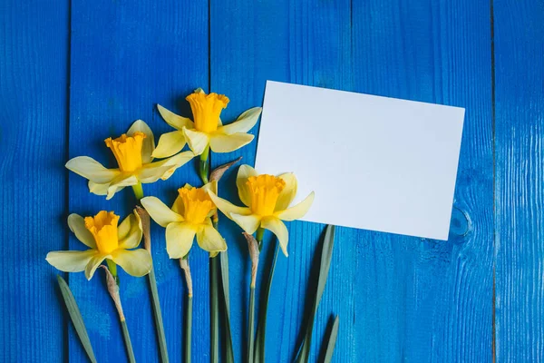 De kaart van de groet van de bloemen. Lente achtergrond met narcissen boeket op houten tafel — Stockfoto