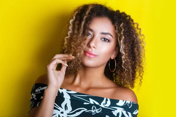 Retrato de beleza da jovem menina afro-americana com penteado afro. Menina posando no fundo amarelo, olhando para a câmera . — Fotografia de Stock