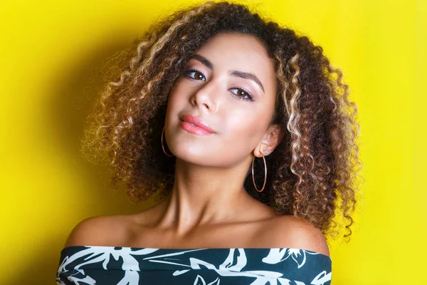 Retrato de beleza da jovem menina afro-americana com penteado afro. Menina posando no fundo amarelo, olhando para a câmera . — Fotografia de Stock