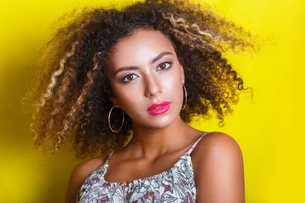 Retrato de beleza da jovem menina afro-americana com penteado afro. Menina posando no fundo amarelo, olhando para a câmera . — Fotografia de Stock
