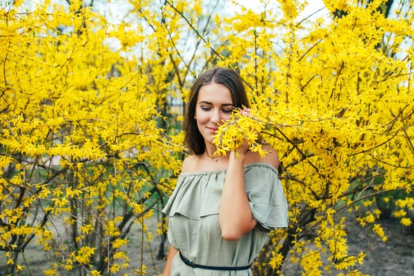 Feliz joven sonriente con flores de primavera en el jardín — Foto de Stock