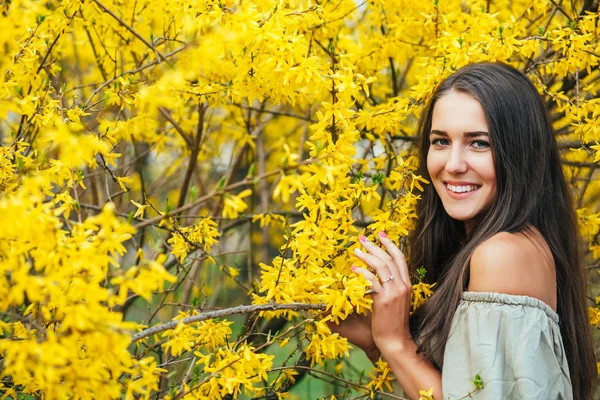 Gelukkig glimlachen jonge vrouw met lente bloemen in de tuin — Stockfoto