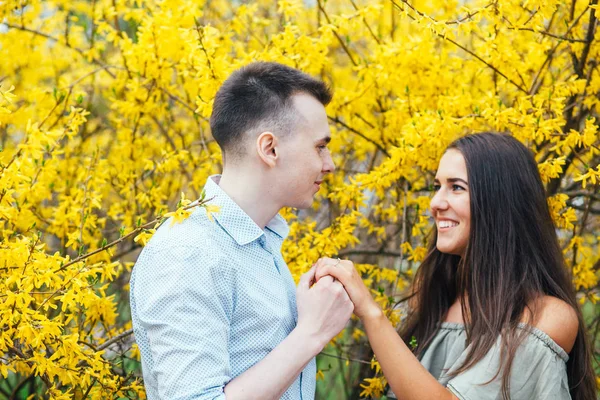 Jovem casal feliz no amor ao ar livre. Homem e mulher em um passeio em um parque florescendo primavera — Fotografia de Stock