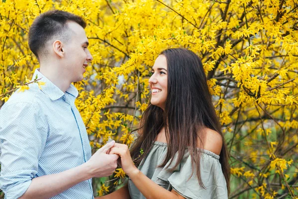 Jeune couple heureux amoureux en plein air. Homme et femme en promenade dans un parc fleuri printanier — Photo