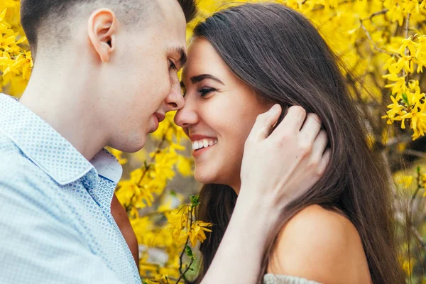 Unga lyckliga par i kärlek utomhus. Man och kvinna på en promenad i en våren blommande park — Stockfoto