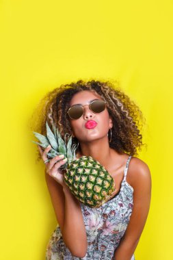 Moda yaz portre afro Amerikan kız güneş gözlüğü ve ananas sarı arka plan üzerinde