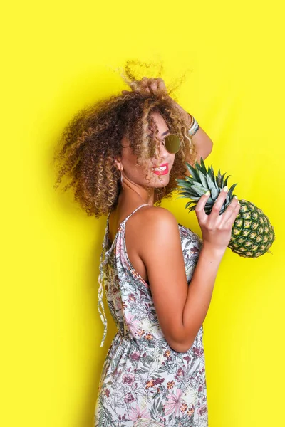 Fashion summer portrait afro american girl in sunglasses and pineapple over yellow background — Stock Photo, Image