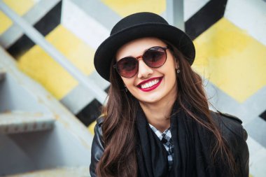 Şık kadın bir şehir sokakta oturan ve kahve veya çay içme .