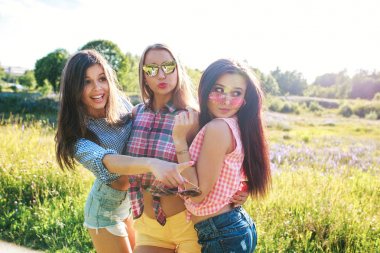 Mutlu arkadaş güneşli bir parkta. Yaz yaşam tarzı portre üç hipster kadınların zevk iyi günler, parlak güneş gözlüğü takıyor. Arkadaşlar kızlar eğleniyor en iyi,