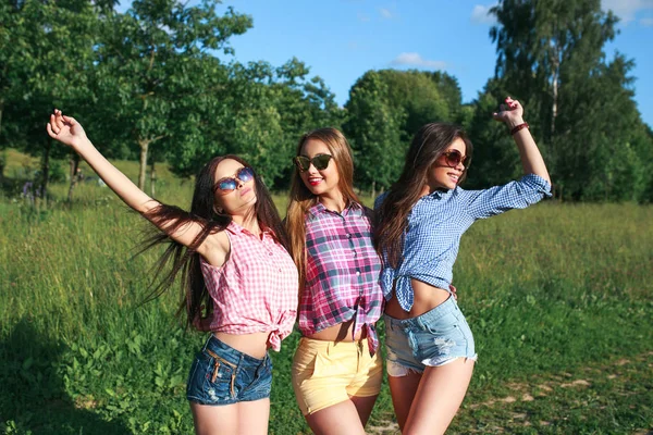 Happy vrienden in het park op een zonnige dag. Zomer levensstijl portret van drie vrouwen van de hipster genieten van mooie dag, heldere zonnebril dragen. Beste vrienden meisjes plezier, — Stockfoto