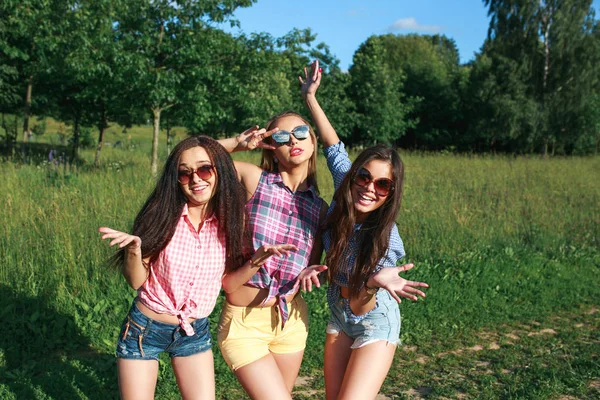 Amigos felizes no parque num dia ensolarado. Estilo de vida de verão retrato de três mulheres hipster desfrutar de bom dia, vestindo óculos de sol brilhantes. Melhores amigos meninas se divertindo , — Fotografia de Stock