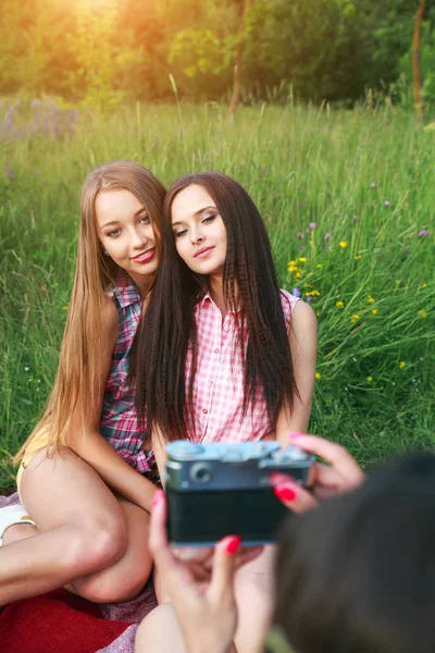 Atractiva mujer joven bonita hablando fotos a sus amigos al aire libre en verano — Foto de Stock
