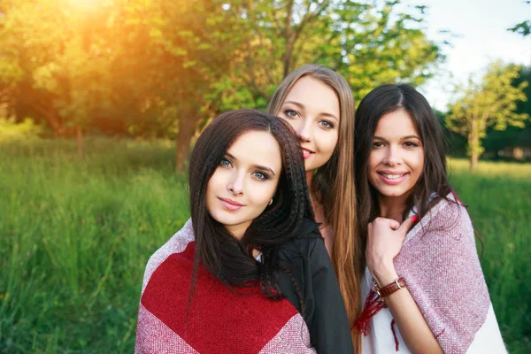 Drie leuke meisjes permanent in de plaid buitenshuis, beste vrienden, met plezier en lachen in park — Stockfoto