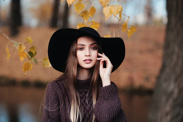 Outdoor atmospheric lifestyle photo of young beautiful lady in black hat — Stock Photo, Image