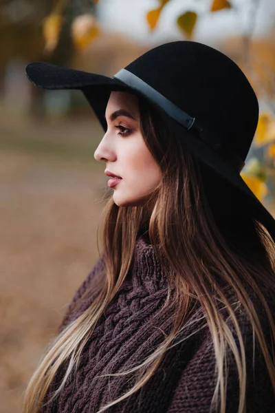 Close-up portrait of stylish girl in elegant black hat in autumn park — Stock Photo, Image
