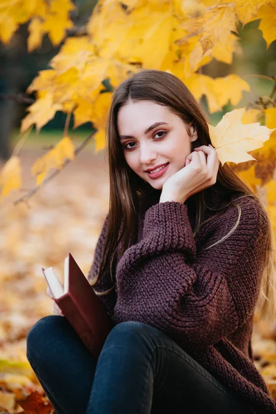 Piękna dziewczyna w jesiennym lesie czyta książkę — Zdjęcie stockowe