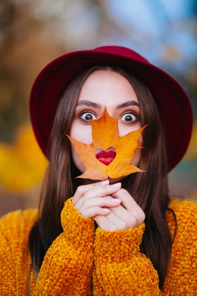 Funny girl with red lips in a hat on a sunny autumn day in park — Stock Photo, Image