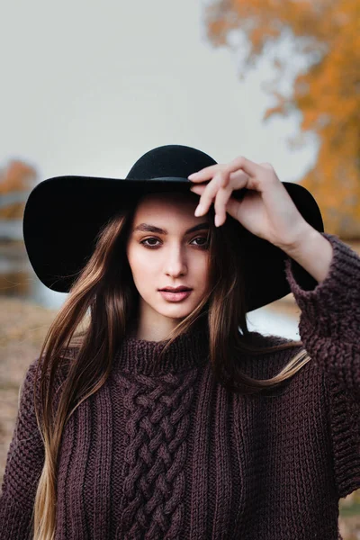 Foto di moda all'aperto di giovane bella donna in cappello nero nel parco autunnale — Foto Stock