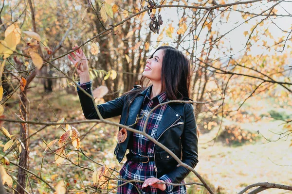 Stylish beautiful woman in plaid shirt dreaming in the autumn park. — Stock Photo, Image