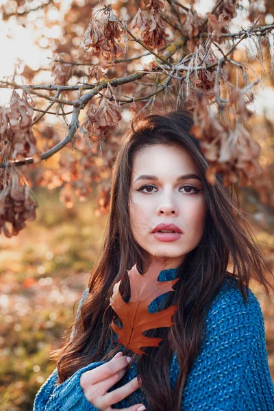 Herfst portret van een mooi jong meisje met een eiken blad in haar handen buiten — Stockfoto