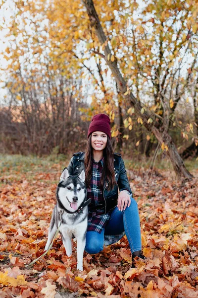 Νεαρή γυναίκα με το σκυλί της στο πάρκο φθινόπωρο — Φωτογραφία Αρχείου