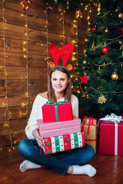 Mujer joven sonriente en suéter y sombrero con muchas cajas de regalo — Foto de Stock