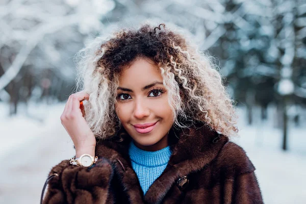 모피 코트를 입고 겨울 공원을 걷고 있는아 프로 미국인 소녀의 근접촬영 사진 — 스톡 사진
