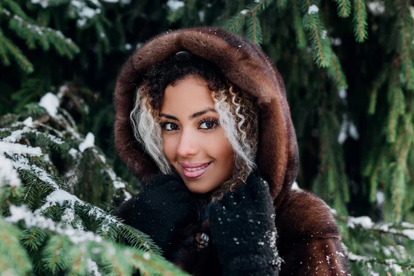 Retrato de cerca de una joven africana con abrigo de piel disfrutando de los momentos de invierno. Concepto vacaciones de invierno . —  Fotos de Stock