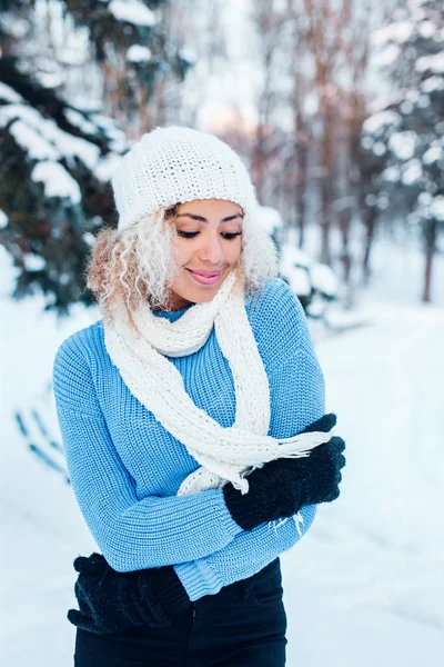 Joven hermosa chica con pelo afro usando sombrero, suéter azul posando en el parque de invierno. Navidad, concepto de vacaciones de invierno . —  Fotos de Stock