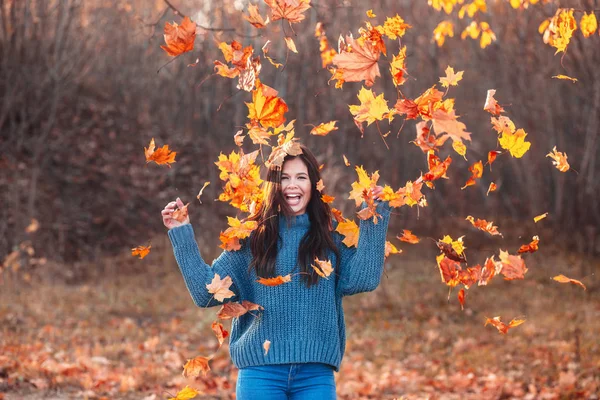 Молода жінка в осінньому парку грає з листям . — стокове фото