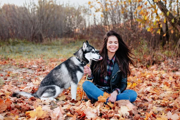 Χαρούμενη νεαρή γυναίκα που απολαμβάνει το σκύλο της στο πάρκο. — Φωτογραφία Αρχείου